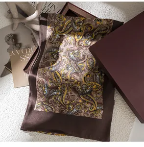 Detalle de una bufanda de seda para hombre con estampado paisley en caja regalo.