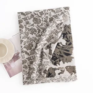 Detailed view of the vintage floral print on a soft faux cashmere scarf with fringes