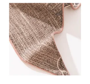 Close-up of silk wool scarf showing herringbone texture and pink hand-rolled edge.