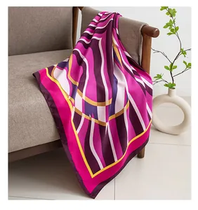 Large printed silk square scarf draped on a modern sofa for a lifestyle display.