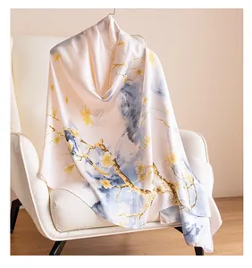 Elegant vintage floral silk shawl draped over a white chair showing delicate texture.