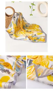 Detailed close-up showing the soft texture and grey hem of a yellow floral silk scarf