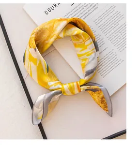 Detail view showing the elegant knot and texture of a yellow mulberry silk neck scarf
