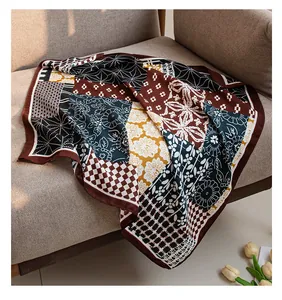 Close-up of a patchwork cotton-linen square scarf with vintage floral patterns on a sofa