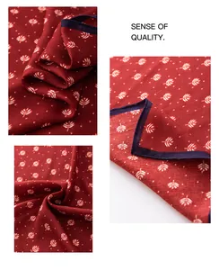 Detailed macro view of burgundy square scarf with white leaf pattern and navy border