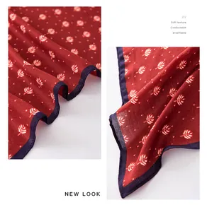 Close-up detail of the breathable red leaf pattern fabric on a soft cotton linen scarf