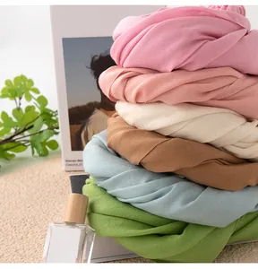 Detailed macro shot of stacked soft wool scarves in various vibrant and elegant pastel colors