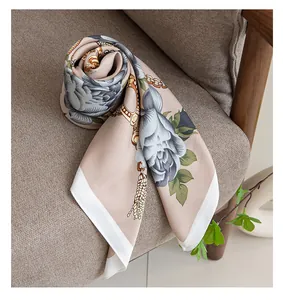 Elegante detalle de un pañuelo de seda sintética con flores en un sillón beige