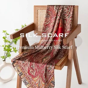 Elegant mulberry silk scarf with intricate red paisley pattern draped on a wooden chair