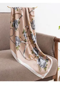 Vista detallada de un elegante pañuelo de seda con estampado de rosas y cadenas oro