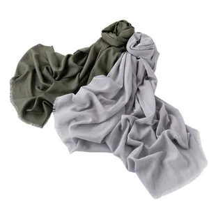 Soft solid color wool scarves in olive green and light purple with fine fringe edges.