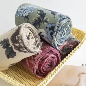 Close-up of soft imitation cashmere scarves with elegant rose prints in a basket