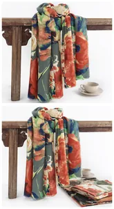 Detail of Chinese style floral print cashmere-like scarf draped on a vintage wooden bench