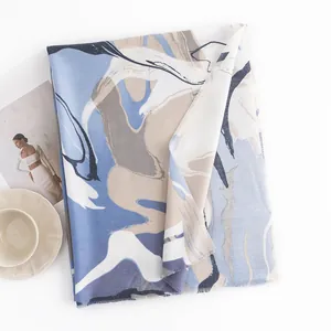 Zachte faux kasjmier sjaal met elegante abstracte blauwe en beige marmerpatronen.
