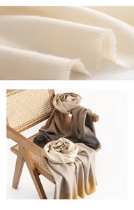 Dettaglio macro del tessuto crema e sciarpe sfumate drappeggiate su una sedia di rattan