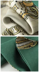 Primer plano del tejido de satén y el estampado de cadenas doradas de este pañuelo verde.