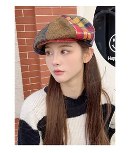 Detailed view of a vintage multi-color patchwork Harris Tweed newsboy cap worn by a model.