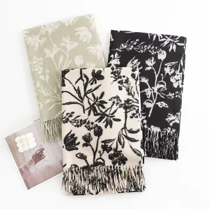 Floral print faux cashmere scarves in sage green, cream, and black with elegant tassels.