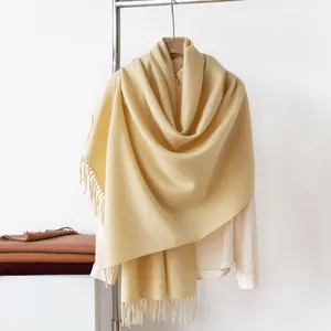 Detail view of a pale yellow imitation cashmere scarf featuring elegant tassel fringe