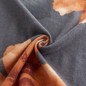 Vista macro di morbido tessuto finto cashmere con elegante stampa a fiori di ibisco arancio.