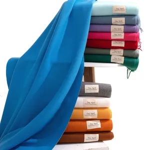 Soft solid color imitation cashmere scarves stacked on a minimalist white shelf