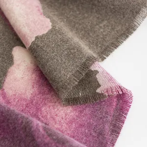 Vista dettagliata della stampa floreale di ibisco su una morbida sciarpa in finto cashmere