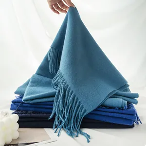 Detail view of high-quality soft blue cashmere-like scarf featuring elegant long fringe tassels