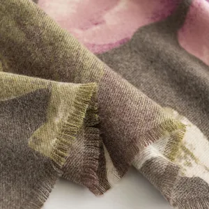 Dettaglio di una morbida sciarpa invernale con stampa a ibisco e trama in finto cashmere