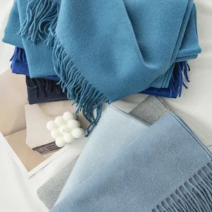 Detailed view of soft blue and grey imitation cashmere scarves with elegant tassel fringe.