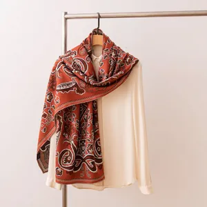 Nahaufnahme eines roten Vintage-Schals mit Paisley-Muster aus Seidenwolle auf einem Kleiderbügel