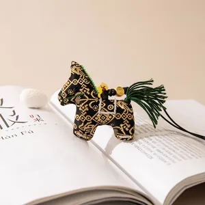 Close-up of a traditional Chinese Song Brocade silk horse charm with gold patterns.