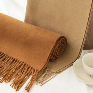 Detailed close-up of brown and tan imitation cashmere scarves with elegant soft tassels