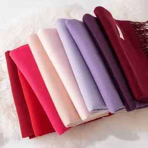 Soft solid cashmere-like scarf with elegant tassels in various warm winter colors.