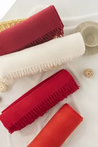 Macro detail view of soft cashmere-like scarves with fringe in various red shades