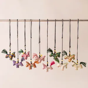 Detailed view of ten colorful silk horse necklaces hanging in a row for 2026 mascot.