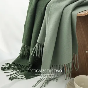 Close-up of dark green and sage green cashmere-like scarves with tassels