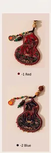 Macro view of handmade silk gourd charms featuring intricate traditional horse embroidery