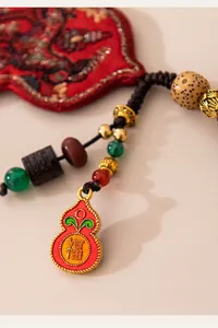 Close-up of handmade silk horse charm with gourd pendant and colorful beads