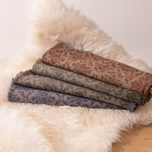 Detailed view of four stacked cashmere pashmina scarves with vintage floral patterns