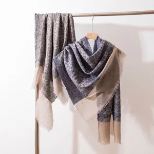 Detail of lightweight cashmere shawl with elegant paisley pattern and frayed edges.