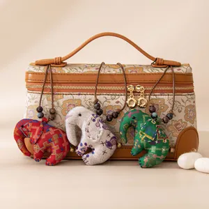 Détail de colliers avec pendentifs éléphants en soie faits main aux motifs ethniques