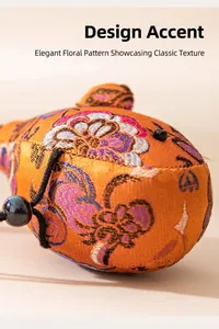 Gros plan d'un charme baleine en soie fait main avec broderies florales traditionnelles