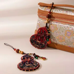 Detailed close-up view of premium handmade silk embroidered horse and gourd charm pendants.