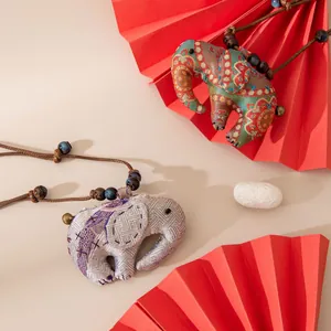 Vue détaillée de pendentifs éléphants en soie faits main avec broderies ethniques et cordon