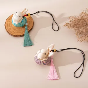 Close-up of handmade silk rabbit charms featuring delicate tassels and textures