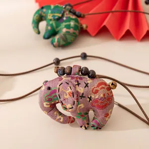 Vue détaillée d'un pendentif éléphant ethnique fait main en tissu de soie de qualité
