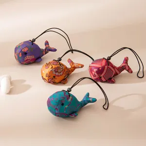 Vue détaillée de pendentifs en soie en forme de baleine avec des motifs ethniques