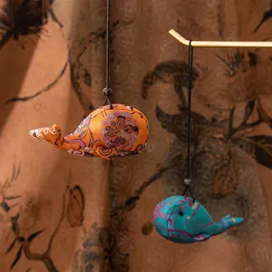 Détail de pendentifs baleine en soie faits à la main avec des motifs traditionnels