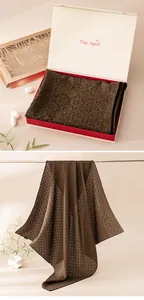 Detailed view of brown Xiangyun silk scarf draped and in elegant gift box