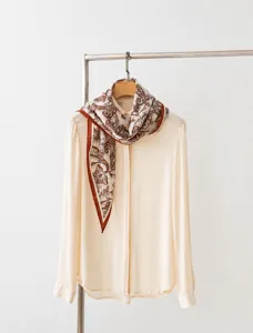 Una bufanda de alta calidad de 30% seda y 70% lana con un elegante estampado de cachemira marrón.